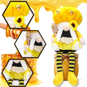 Macro details of bee gnome plush with sunflower hat, striped legs, and wooden honey dipper