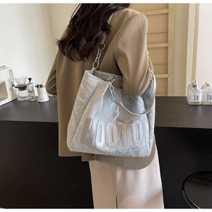 Close-up of metallic silver tote bag with HOOTO logo and chain strap in daily life scene