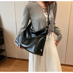Close-up of black hobo bag showing vintage wrinkled texture and knotted shoulder strap detail