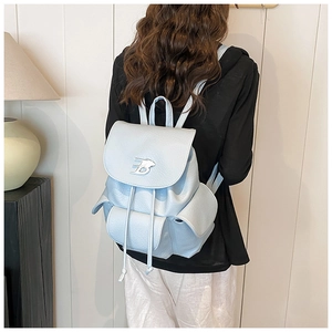 Detail of light blue pebble leather backpack featuring silver B-logo and drawstring flap