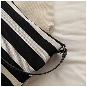 Detailed view of striped canvas texture with sleek black leather strap and metal link
