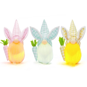 Three glowing Easter gnome plush dolls with rabbit ears and carrots on white background