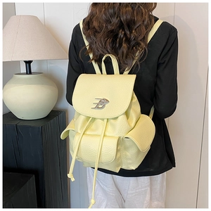 Detail view of yellow lychee leather backpack with B buckle and buckle pockets