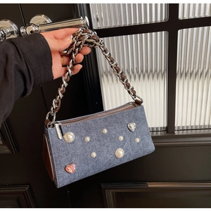 Détail du sac sous le bras en denim bleu avec perles et cristaux en forme de cœur