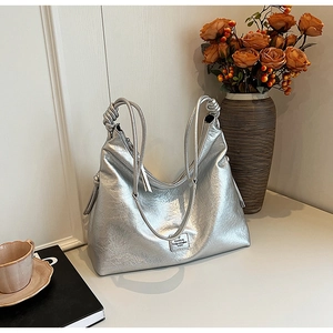 Detail view of the silver metallic wrinkled texture and handle knot on this bucket bag