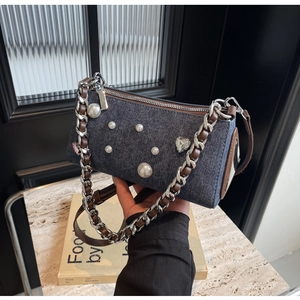 Détail du sac à bandoulière en denim avec perles, strass et sangle de chaîne tissée