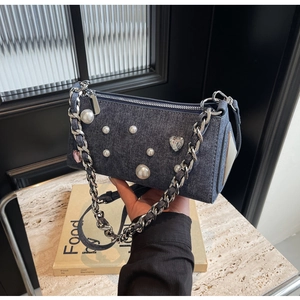 Détail du sac bandoulière en denim avec perles blanches, strass cœur et chaîne métallique
