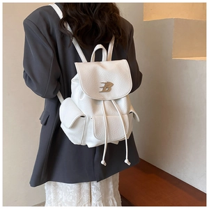 Detail of white lychee-textured leather backpack with drawstring and metal logo
