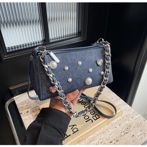Détail du sac bandoulière en denim bleu avec perles, cœur cristal et bandoulière