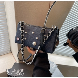 Détail du sac à bandoulière en denim bleu avec perles blanches, cœur rose et chaîne