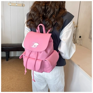 Detailed view of pink leather backpack with silver B-logo and drawstring closure