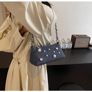 Détail du sac à bandoulière en denim avec perles blanches et cœurs en cristal rose devant