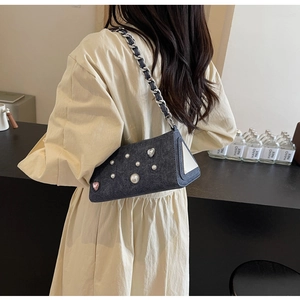 Détail du sac sous le bras en denim bleu avec perles blanches et cristaux en forme de cœur