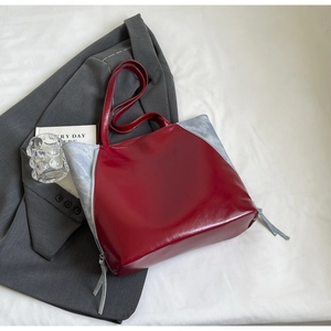 Detailed close-up of large contrast color tote bag with red lacquer and blue suede textures