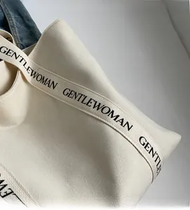 Macro detail of canvas tote bag with GENTLEWOMAN letter print strap and durable texture