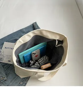 Interior view of spacious white canvas tote bag showing striped lining and items