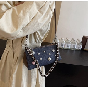 Détail du sac bandoulière en denim avec perles et strass coeur sur un modèle