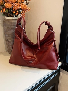 Large burgundy leather tote bag with dual knotted shoulder straps and drawstring detail