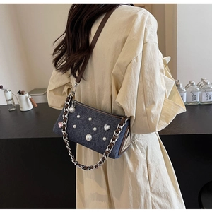 Gros plan détaillé du sac en denim bleu foncé avec perles et strass en forme de cœur