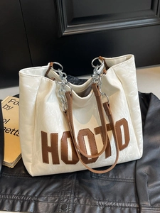 White textured tote bag with brown leather chain handles and HOOTO lettering