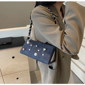 Détail du sac en jean bleu avec perles, strass et bandoulière en chaîne argentée