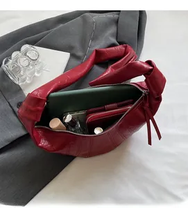 Large red crescent shoulder bag showing interior space for tablet and essentials