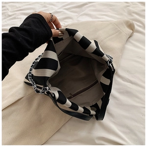 Detailed view of striped canvas tote interior with zipper pocket and magnetic closure