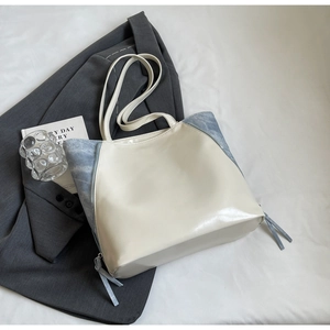 Detail of contrast color tote bag with beige leather and blue marble texture accents