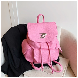 Detail of pink lychee leather backpack with drawstring closure and silver bird logo