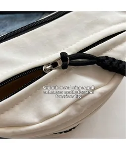 Detailaufnahme des glatten Metallreißverschlusses mit schwarzer Kordel an weißer Tasche