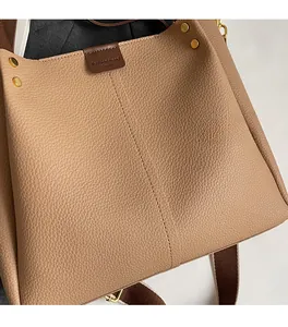 Detail of beige tote bag with litchi grain leather and wide woven shoulder strap