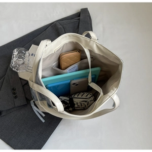 Top view of spacious interior of cream and grey tote bag with daily essentials inside