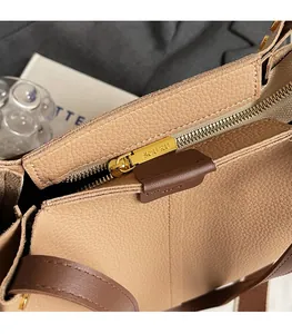 Detailed close-up of golden metal zipper and pebble grain leather on a large tote bag