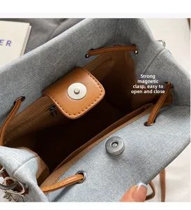 Detail view of denim bucket bag with magnetic closure and interior zipper pocket