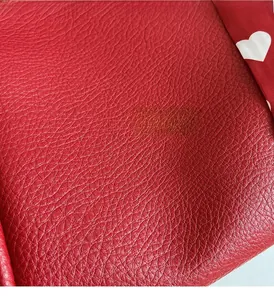 Detailed close-up of red lychee pattern leather texture for large capacity tote bag