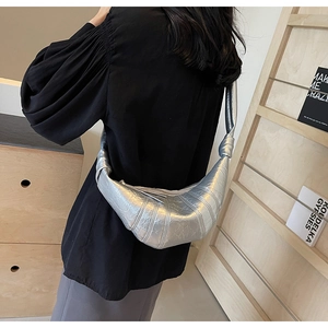 Detailed side view of silver metallic croissant bag with signature pleated stitching