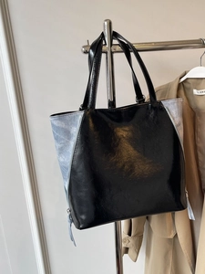 Modern black glossy tote bag with blue denim side panels and large capacity design