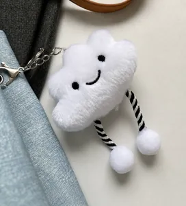 Close-up of cloud-shaped plush charm with smiling face and striped cord legs