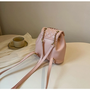 Dettaglio dello zaino mini rosa trapuntato con catena di lusso e texture in pelle liscia
