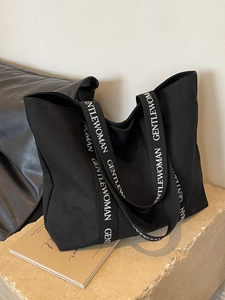 Minimalist black canvas tote bag with white GENTLEWOMAN lettered strap for daily use