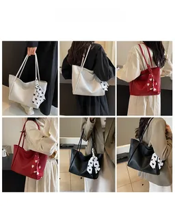 Detail view of large tote bags in white, red, and black with decorative heart silk scarves