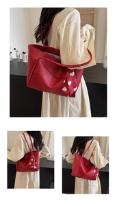 Detail of red lychee grain tote bag with heart pattern scarf on long shoulder straps