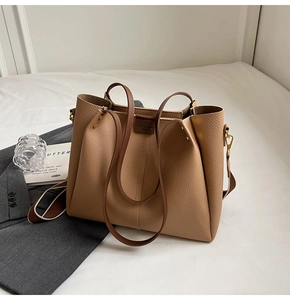 Detail of caramel leather tote bag showing lychee grain texture and magnetic buckle