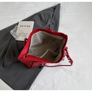 Internal view of a large red tote bag with textile lining, zipper pocket and decorative scarf