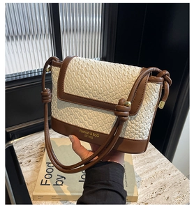 Détail du sac en paille tissée avec garniture en cuir et bandoulière à nœud