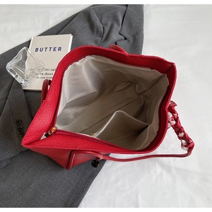 Detail view of red pebbled leather tote bag with interior pockets and silk scarf handle