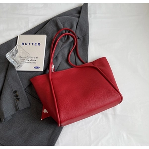 Detail of red litchi texture tote bag on a blazer background for minimalist style