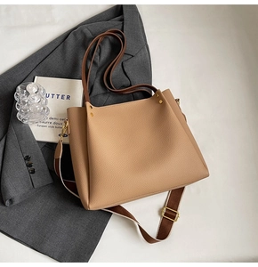 Detail view of khaki tote with lychee grain texture and stylish wide woven strap