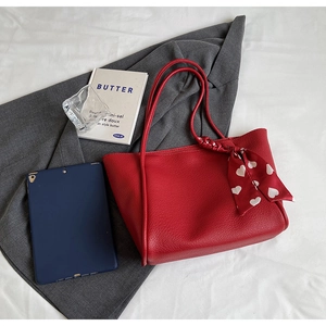 Detail of red lychee grain leather tote bag with silk scarf and large capacity