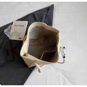 Close-up of the pebbled leather tote interior with grey lining and a silk scarf handle